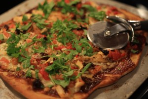 Top pizza with fresh arugula.  Cut pizza into slices and serve.