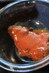 Place a chicken tender in a bowl, and coat chicken with desired amount of buffalo wing sauce.  Place chicken on cutting board, and cut into bit size pieces.