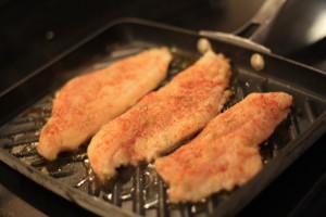 Season each side of catfish filet with salt, ground black pepper, paprika, lime zest, chili powder, and garlic powder.  Drizzle juice of ½ lime onto filets.  Heat 1 tablespoon olive oil on grill pan.  Sauté each filet, turning ½ way through cooking.  About 3-4 minutes per side.  Fish should be opaque and flake easily with a fork when finished.  