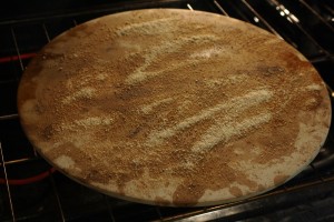 Sprinkle some breadcrumbs or cornmeal onto your pizza stone or pan.  This will help to keep the pizza from sticking.  