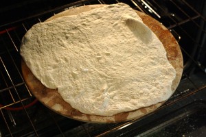 Transfer the pizza crust to the stone and bake for 5 minutes.  The stone will be hot, so be careful; use oven mitts or hot pads when handling the stone/pan.