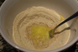 Using a fork, start stirring from the middle and gradually adding in flour from the inside of the well.  As is mixes, flour will fall in from the outer portions.  