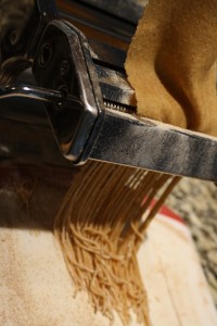 Now it’s time to cut into the shapes.  Move the crank to the pasta shape you desire (the spaghetti shape or fettuccini shape; I‘m using the spaghetti shape in these pictures, but it works just the same for the fettuccini shape.).  Roll the pasta through, and pasta will be cut into desired shaped noodles.   