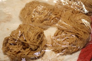 Lay the noodles in a pile on the floured board.  Cover with plastic wrap.  Repeat all steps for each section of pasta dough.
