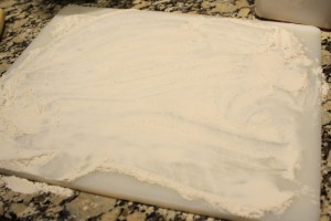 On a cutting board, spread a thin layer of about ¼ cup of flour.  