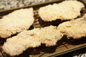 Set a baking rack on a baking sheet.  Spray the rack with cooking spray.  Set each piece of panko-coated chicken onto the rack.  