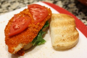 Place a leaf of lettuce on one slice of toasted bread, then a Buffalo wing sauce-smothered chicken cutlet, then a slice of tomato cut in half.