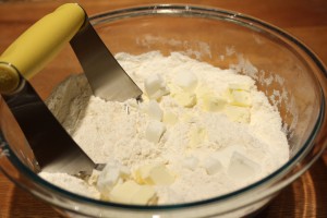 Next add in the cold butter and cold vegetable shortening.  Blend with a pastry blender.  You’ll want the mixture to resemble crumbs, as you’ll see in the next photograph.  If you don’t have a pastry blender, just use two forks.