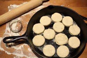 Set each biscuit into a cast-iron skillet.  If you don’t have a cast-iron skillet, you could use a cake pan that’s been greased with butter or vegetable shortening.  Brush each biscuit with the melted butter. 