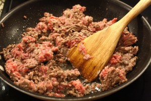 As the beef and sausage cook, give it a little mash to break up into chunks.