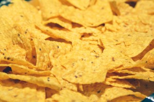 Layer tortilla chips onto a foil covered baking sheet.  The size of baking sheet I used is a 15.25 inch x 10.25 inch x .75 inch.