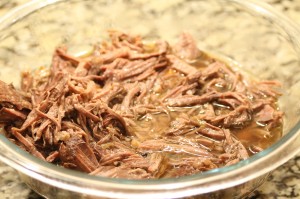 Remove the carrots and onions from the slow cooker with a slotted spoon.  Add in the shredded beef.   Pour a couple of ladlefuls of broth over the beef and veggies.