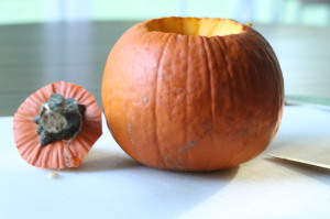 Wash the pumpkin and dry it off.  Cut around the stem and remove the top (you want to cut just large enough so your hand will fit in.  Discard the top.