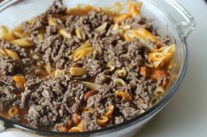 Top the chili evenly with the browned ground beef.  Pour the beef broth over the layers.