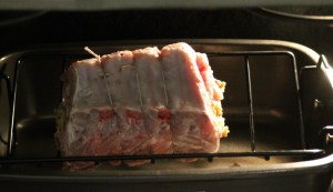 Place the roast into a roasting pan on a roasting rack (you’ll want the bones sticking up).  You may have to cover the exposed bones with foil to prevent from burning.  Pour the wine and water into the bottom of the roasting pan.